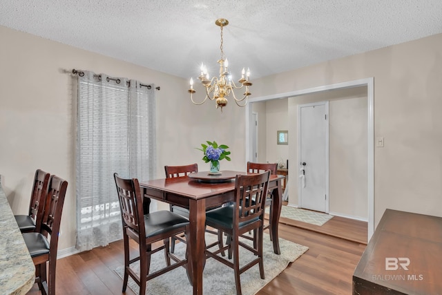 108 Paige Cir, Daphne, AL 36526 - dining area with a chandelier, wood finished floors, a textured ceiling, and baseboards