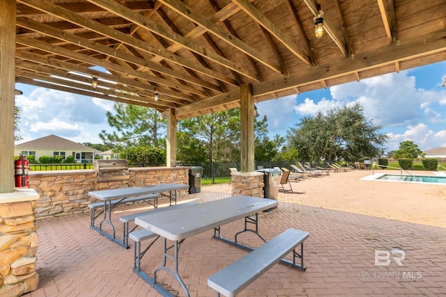 view of patio with a community pool and area for grilling