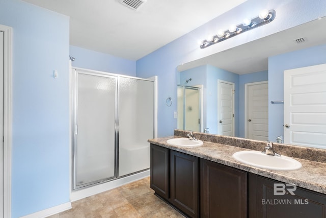 bathroom with vanity and a shower with door