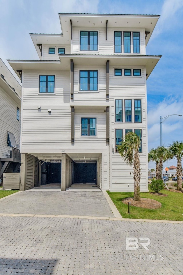 exterior space featuring a carport and decorative driveway