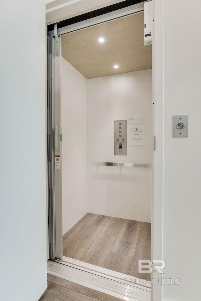 interior space featuring recessed lighting, elevator, and wood finished floors