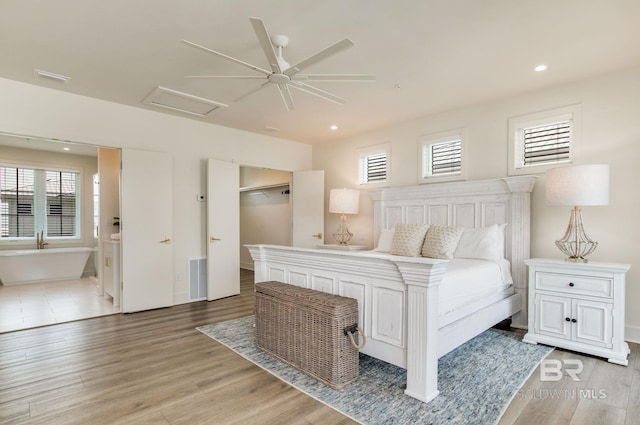 bedroom featuring light wood-type flooring, visible vents, recessed lighting, connected bathroom, and attic access