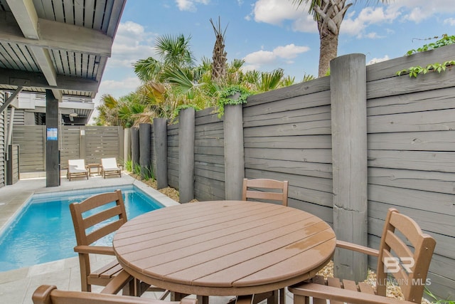 exterior space with outdoor dining area, a fenced in pool, a fenced backyard, and a patio area