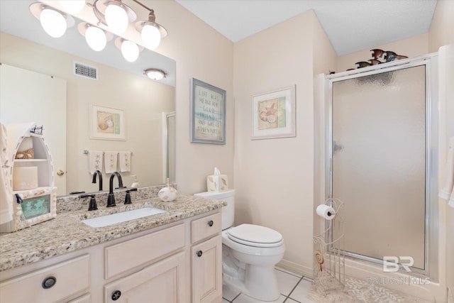 bathroom with vanity, a shower with shower door, tile patterned floors, and toilet