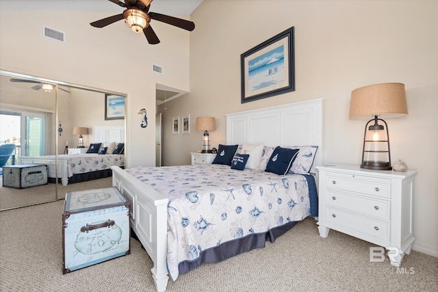 bedroom featuring light colored carpet, high vaulted ceiling, a closet, and ceiling fan