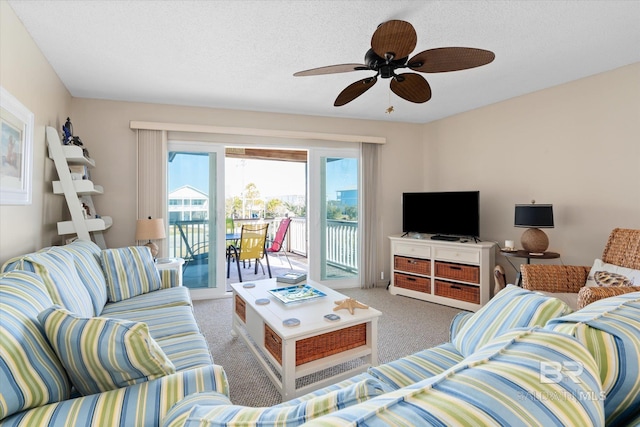 living room featuring ceiling fan, carpet floors, and a textured ceiling