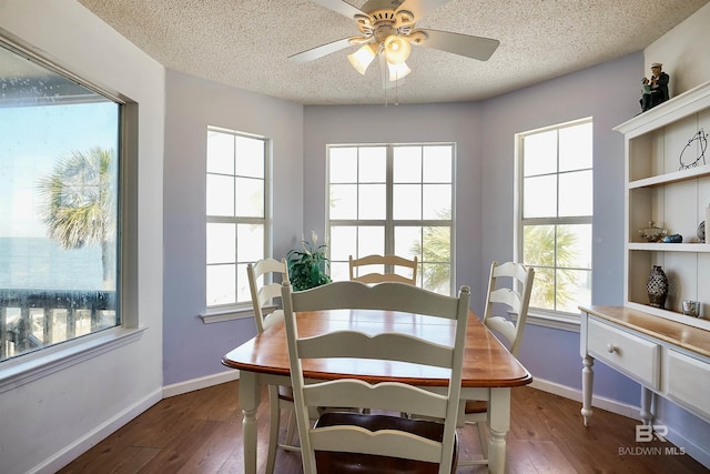 747 Cherokee Rd, Gulf Shores, AL 36542 - dining area featuring a healthy amount of sunlight, dark wood finished floors, and a textured ceiling