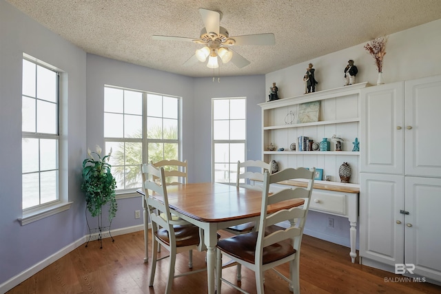 747 Cherokee Rd, Gulf Shores, AL 36542 - dining area featuring a textured ceiling, baseboards, dark wood finished floors, and a ceiling fan