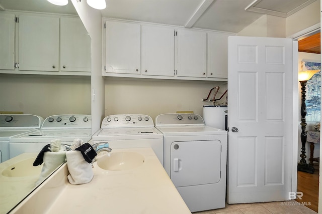 747 Cherokee Rd, Gulf Shores, AL 36542 - laundry area featuring cabinet space, washer and clothes dryer, gas water heater, and light tile patterned flooring