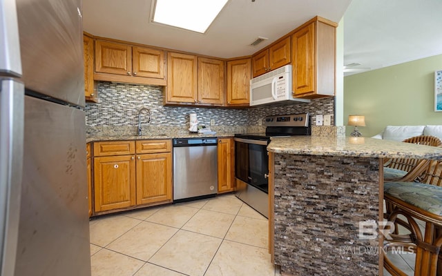 24230 Perdido Beach Blvd Unit 3112, Orange Beach, AL 36561 - kitchen with visible vents, light stone counters, tasteful backsplash, appliances with stainless steel finishes, and light tile patterned floors