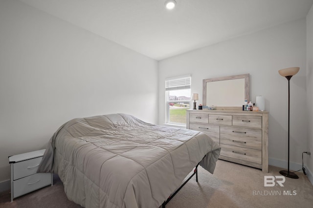 bedroom featuring light colored carpet and baseboards