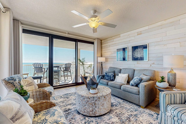 25020 Perdido Beach Blvd Unit 1101B, Orange Beach, AL 36561 - living area with wood finished floors, ceiling fan, a textured ceiling, and wooden walls