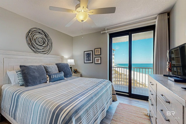 25020 Perdido Beach Blvd Unit 1101B, Orange Beach, AL 36561 - bedroom featuring access to exterior, light wood finished floors, a textured ceiling, and a ceiling fan