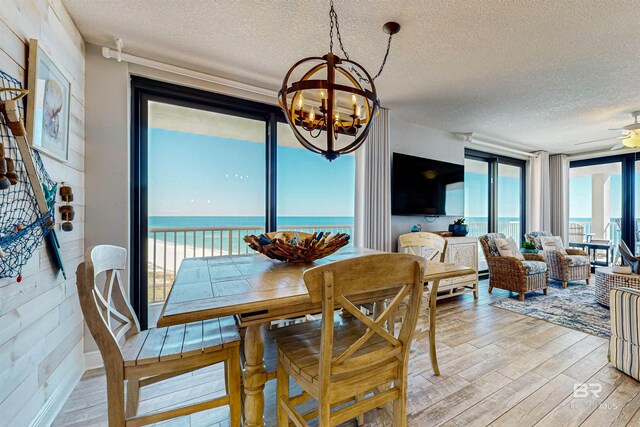 25020 Perdido Beach Blvd Unit 1101B, Orange Beach, AL 36561 - dining room featuring a chandelier, light wood finished floors, a textured ceiling, and ceiling fan