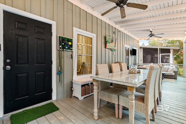 wooden deck with ceiling fan, outdoor dining area, and a sunroom