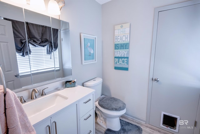 112 W 8th Ave Unit 7, Gulf Shores, AL 36542 - bathroom with toilet, vanity, wood finished floors, and heating unit