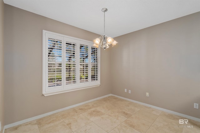 tiled spare room with an inviting chandelier