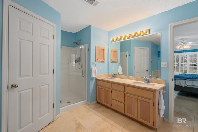 bathroom with tile patterned floors, walk in shower, vanity, a textured ceiling, and ceiling fan