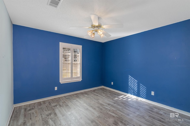 spare room with ceiling fan, wood-type flooring, and a textured ceiling