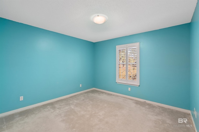 carpeted empty room with a textured ceiling