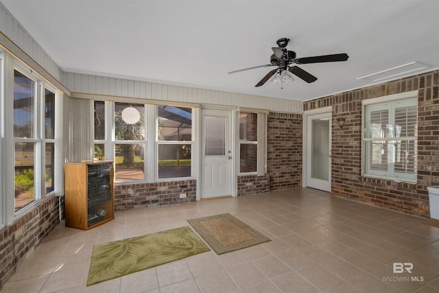 unfurnished sunroom with ceiling fan and a wealth of natural light