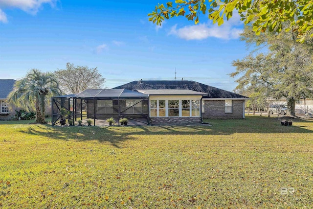 rear view of house featuring a lanai and a yard