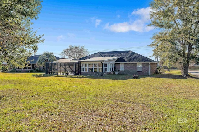 back of property featuring a sunroom and a yard