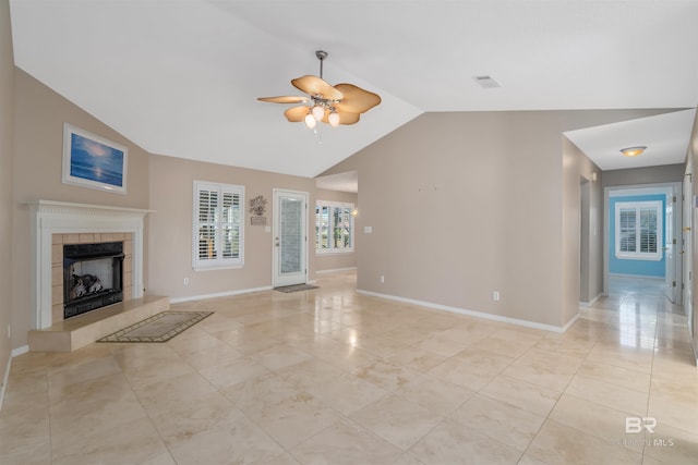 unfurnished living room featuring ceiling fan, light tile patterned flooring, a tiled fireplace, and vaulted ceiling