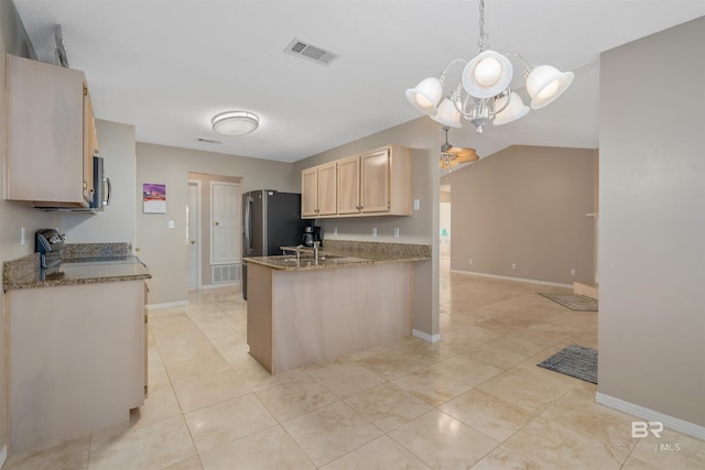 kitchen featuring pendant lighting, light brown cabinetry, light tile patterned flooring, stainless steel appliances, and a chandelier