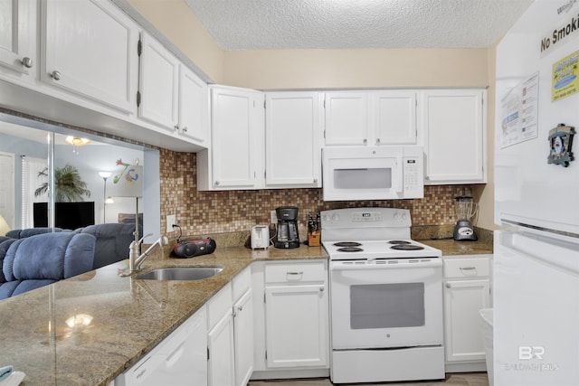 952 W Beach Blvd Unit 210, Gulf Shores, AL 36542 - kitchen featuring white appliances, a sink, a textured ceiling, white cabinets, and light stone countertops