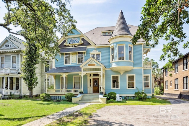 victorian home featuring covered porch and a front yard