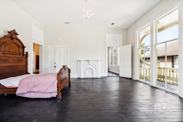 bedroom with access to outside, a chandelier, and dark hardwood / wood-style floors