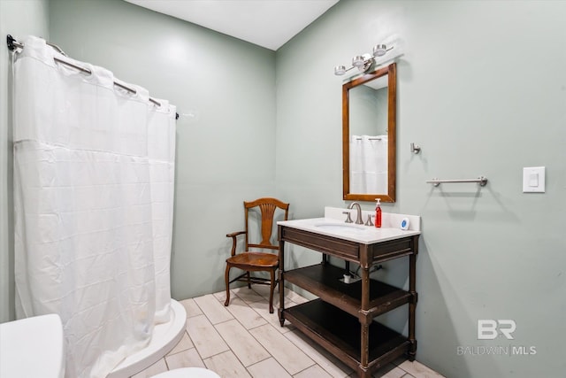 bathroom with curtained shower, sink, and toilet