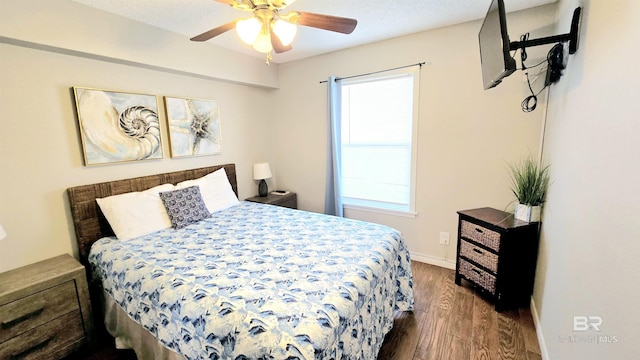 bedroom with ceiling fan, dark hardwood / wood-style flooring, and multiple windows