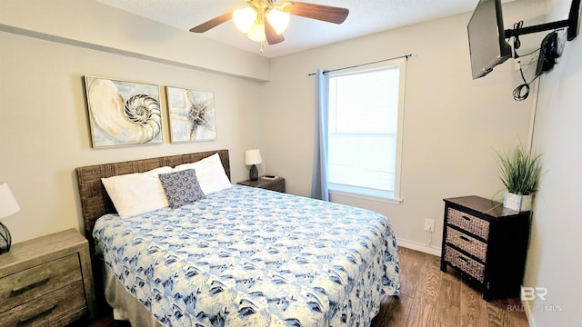 bedroom with ceiling fan, wood-type flooring, and multiple windows