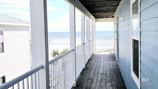 balcony featuring a water view and a beach view