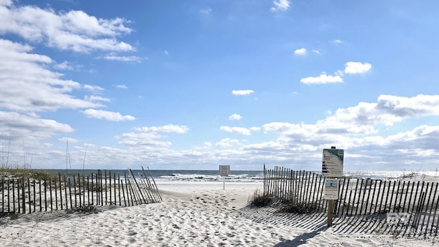 view of patio / terrace with a water view and a beach view