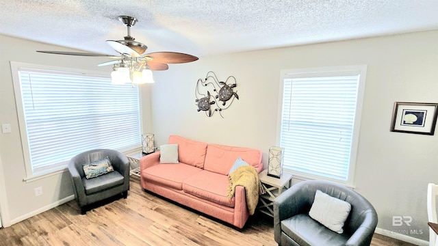 living room with plenty of natural light, a textured ceiling, and light hardwood / wood-style flooring