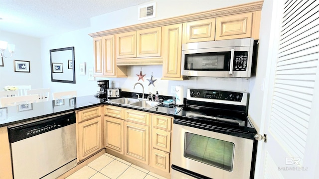 kitchen featuring light tile patterned floors, appliances with stainless steel finishes, a textured ceiling, a chandelier, and sink