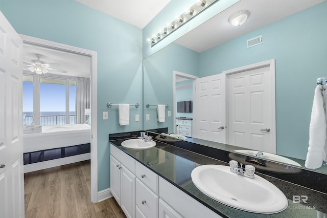 ensuite bathroom with ensuite bath, visible vents, a sink, and wood finished floors