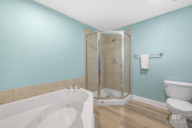 full bathroom featuring a stall shower, toilet, a tub with jets, and wood finished floors