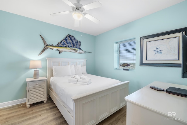 bedroom featuring ceiling fan, light wood-style flooring, and baseboards