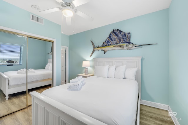 bedroom with light wood finished floors, a closet, visible vents, and baseboards