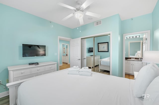 bedroom featuring a closet, visible vents, a ceiling fan, wood finished floors, and baseboards