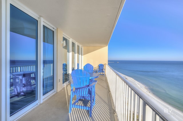 balcony featuring a water view and a beach view