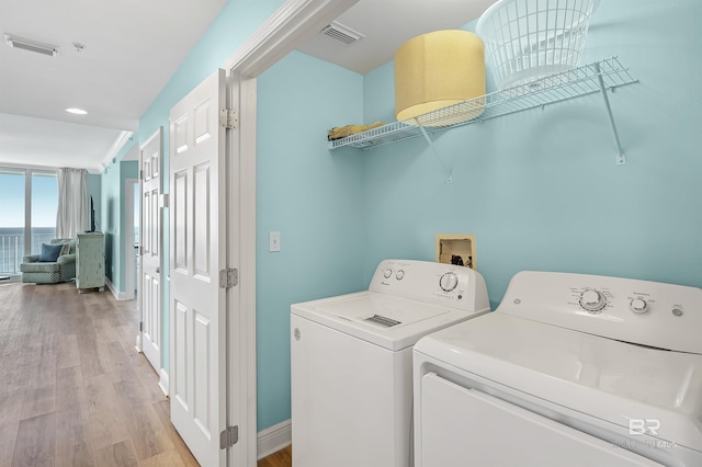 washroom with laundry area, light wood finished floors, independent washer and dryer, and visible vents