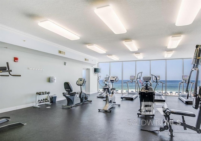 exercise room with a healthy amount of sunlight, floor to ceiling windows, and a textured ceiling