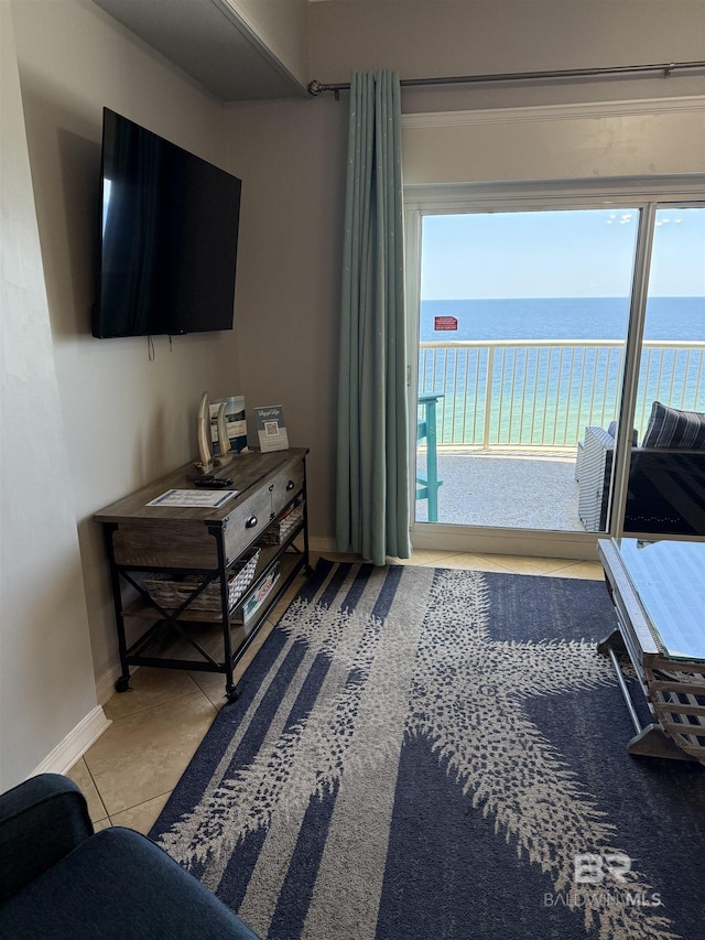 tiled living room with a water view and baseboards