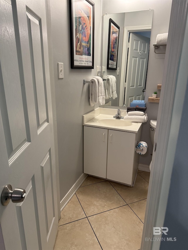 bathroom featuring baseboards, tile patterned floors, vanity, and toilet