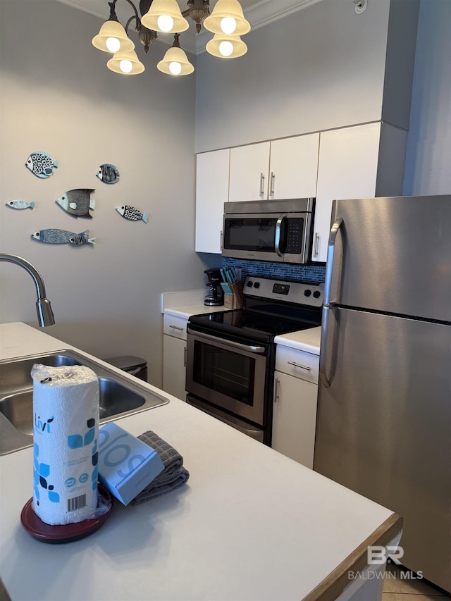 kitchen featuring a sink, white cabinetry, a chandelier, light countertops, and appliances with stainless steel finishes
